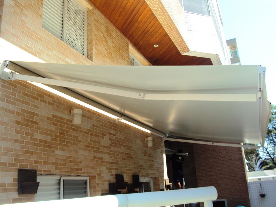 Toldo articulado aberto sobre área de lazer